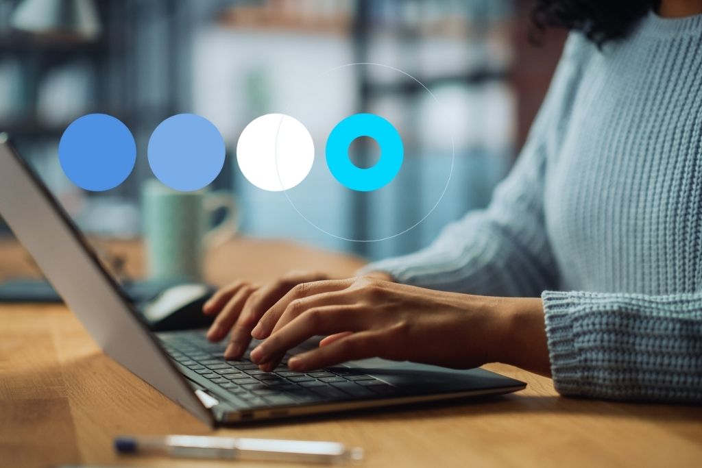 Detalhe de mãos femininas em escritório, utilizando notebook para pesquisar como recusar uma entrevista de emprego.