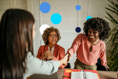 Homem e mulher apertando as mãos durante entrevista de emprego, em escritório empresarial. 