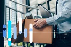 Funcionário carregando caixa com itens de escritório, após pedir demissão.