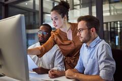 Três profissionais de RH pesquisando onde e como contratar profissional de TI hoje.