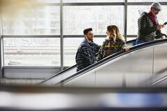 Smiling people on a escalator in a train station.