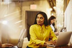 Woman working on her laptop while having a conversation