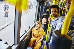 Smiling people looking outside from the bus.