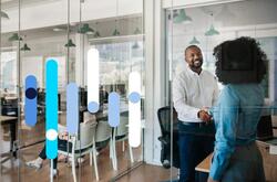 Homem e mulher apertam as mãos em escritório de RH em empresa, após entrevista de emprego.