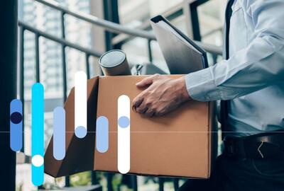 Funcionário carregando caixa com itens de escritório, após pedir demissão.