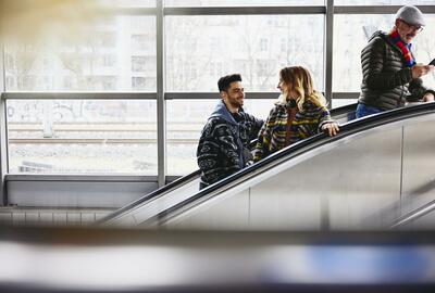 Smiling people on a escalator in a train station.