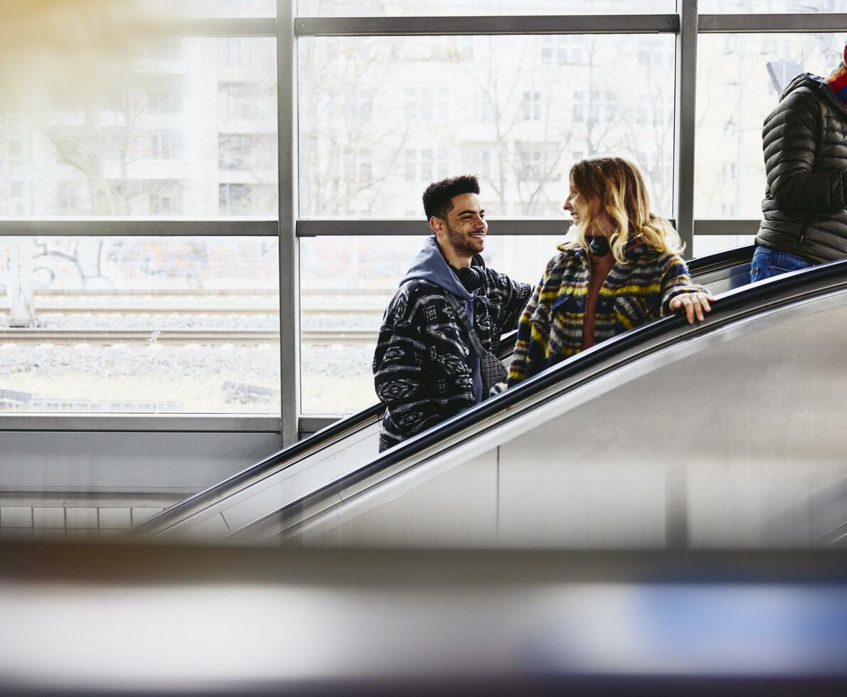 Smiling people on a escalator in a train station.