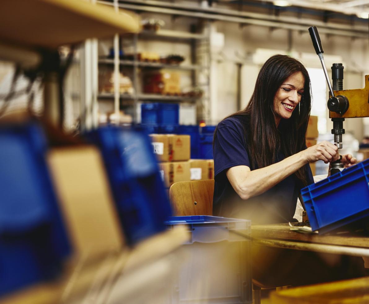 Smiling woman working on a production site.