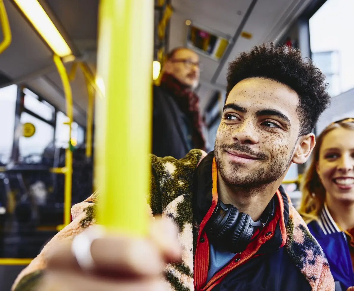 Womale and boy smiling, sitting in a bus.
