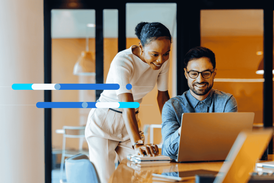 Tecnologia no trabalho sendo utilizada por homem e mulher sorridentes em um escritório.