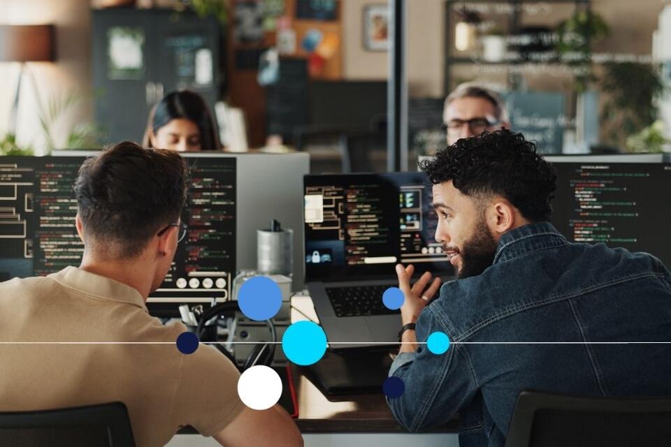 Quatro profissionais de TI trabalhando em escritório de tecnologia.