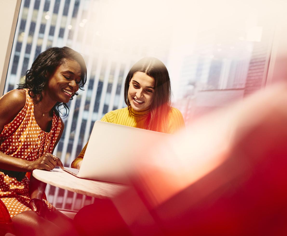 Two smiling women working together outplacement para empresas